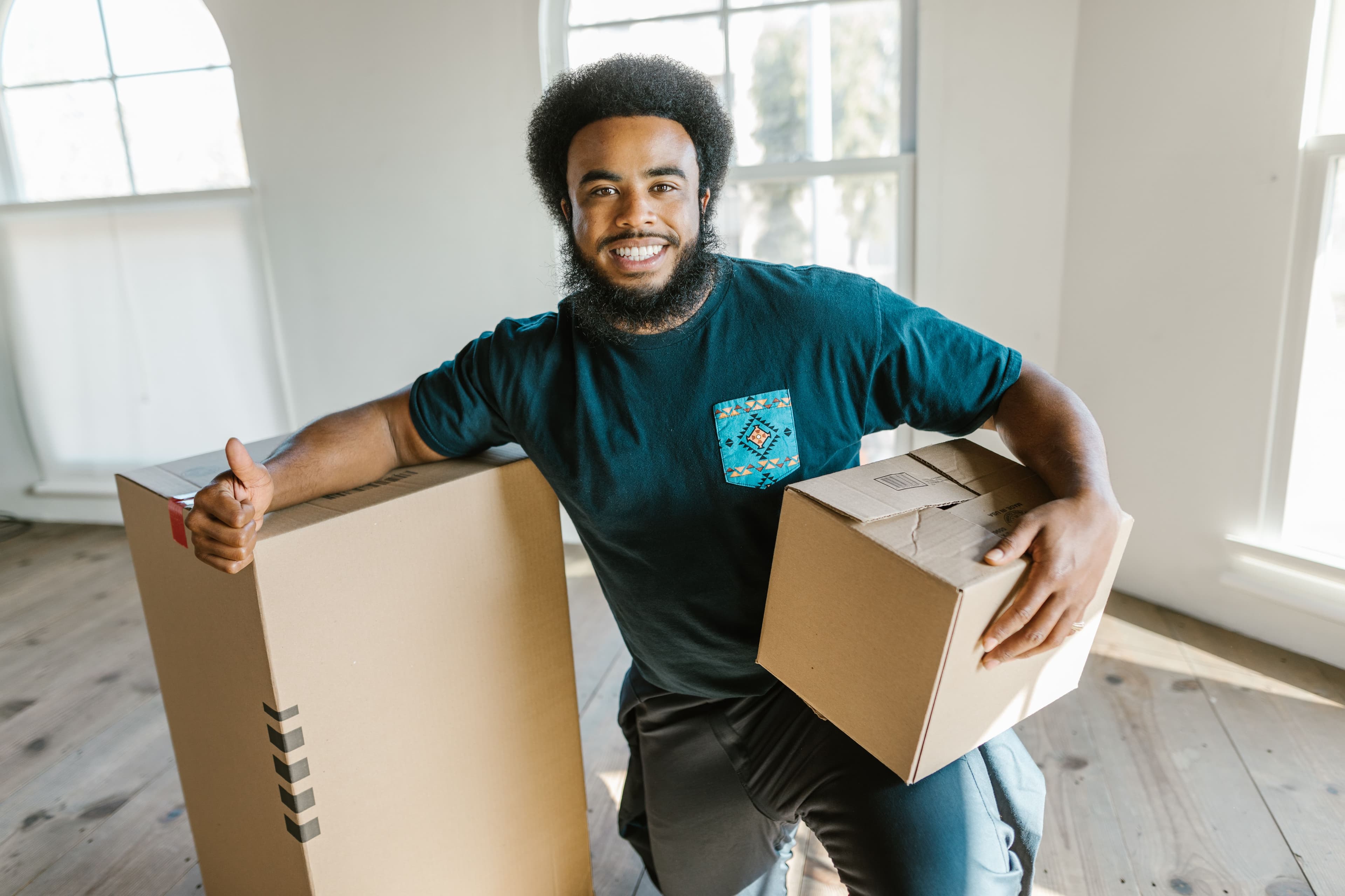 Two professional movers working together to load boxes indoors